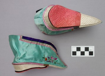 A pair of lotus shoes from the Jiangsu and Zhejiang region of eastern China. They have a characteristic &lsquo;ladder&rsquo; fastening down the vamp (early 20th century; TRC 2013.0063a-b).
