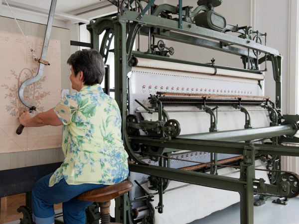 Woman operating the pentograph of a hand embroidery machine, Textielmuseum St Gallen.