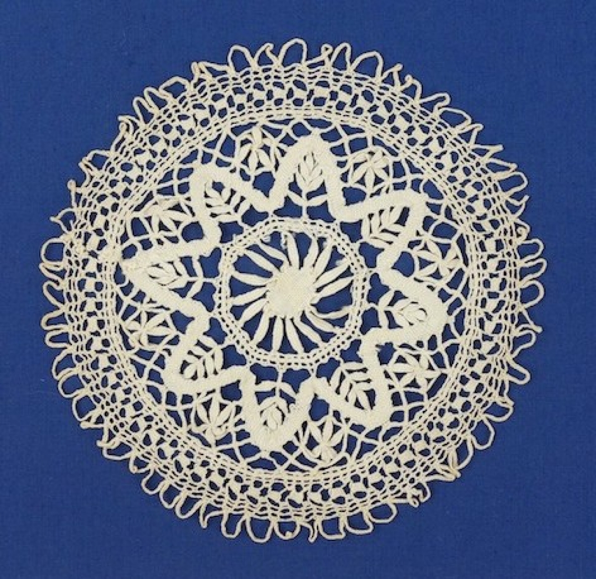Round doily in handmade guipure bobbin lace.