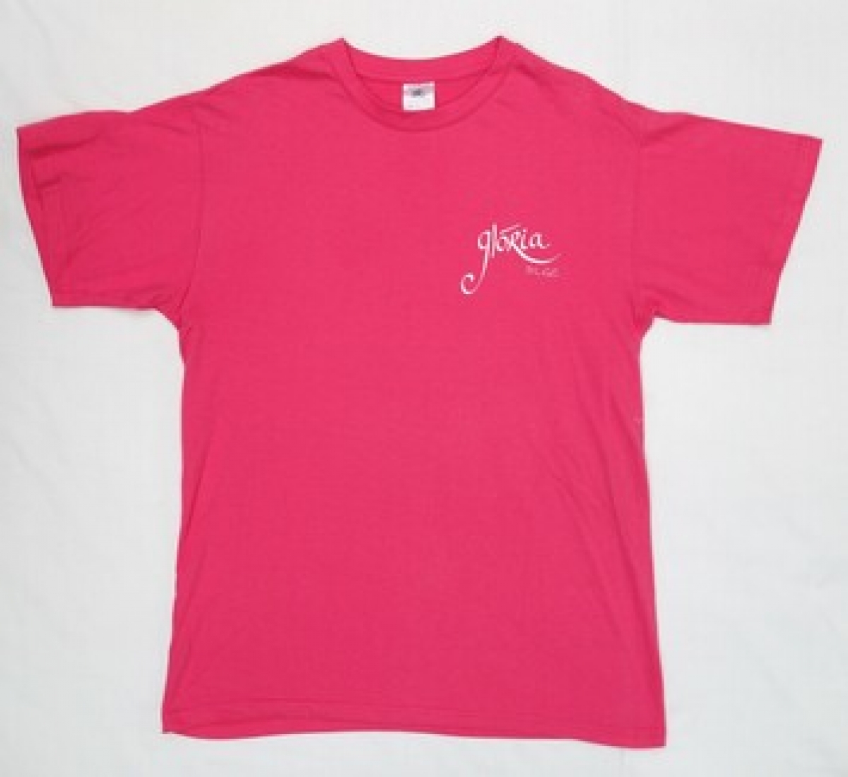 A pink t-shirt with the name GLÓRIA DLGC on the front and a large stylised shamrock with VARIOUS VOICES DUBLIN on the back. Ireland, early 21st century.