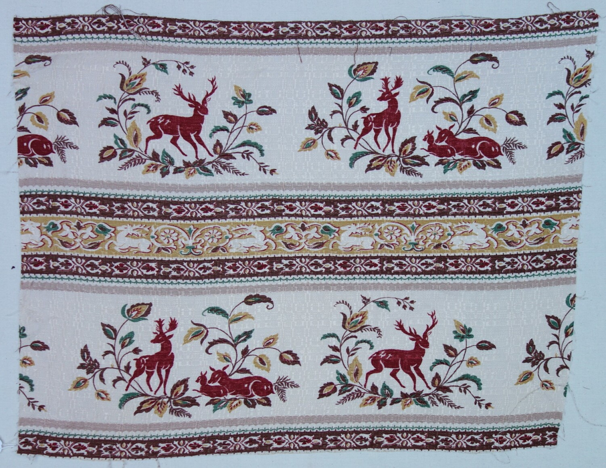 Printed textile with an allover design of bands with stylised stags, deer and fawns in dark red next to Indian-style foliage.