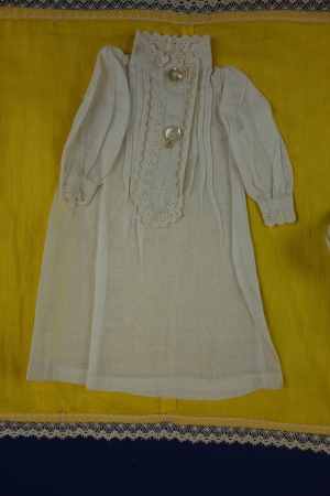 Part of a sampler ('Pronkstuk') made in 1909 by Cato de Keijzer (TRC 2014.0938). The sampler is more than seven metres long. The nightdress is a miniature garment stitched onto the sampler.