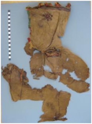 Remains from the site of Kellis, Egypt, of an embroidered tunic with hood placed on the body of a baby with a reconstruction, below, of how it would have been worn (object number 31/420-C5-2/272, 4th century.