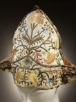 A mid-18th century undress cap from Italy. It is decorated with stylised flowers, as well as metal threads and spangles.