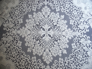Detail of an oval table cloth made of quaker lace.