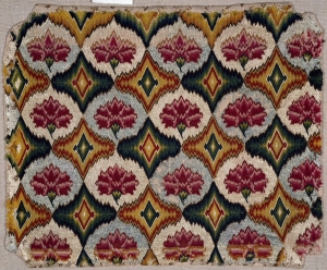 An example of a seat cover decorated with geometric and stylised flowers in Florentine work. It is worked on a linen canvas ground using silk threads (early 18th century; British)