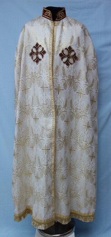 Modern priest's cape from the Coptic Church, Egypt. Brocaded cloth, with woven designs of wheat, grapes and crosses, as well as two large red machine embroidered crosses (TRC 2001.0246d).