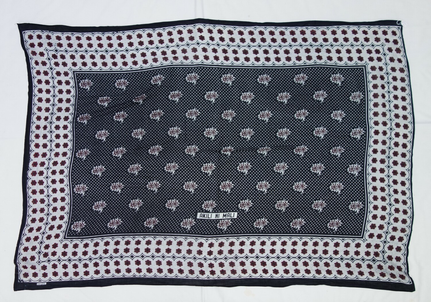 Zanzibari kanga, 2004 (TRC 2004.0144). The text states: AKILI NI MALI (translation: "Intelligence is wealth").