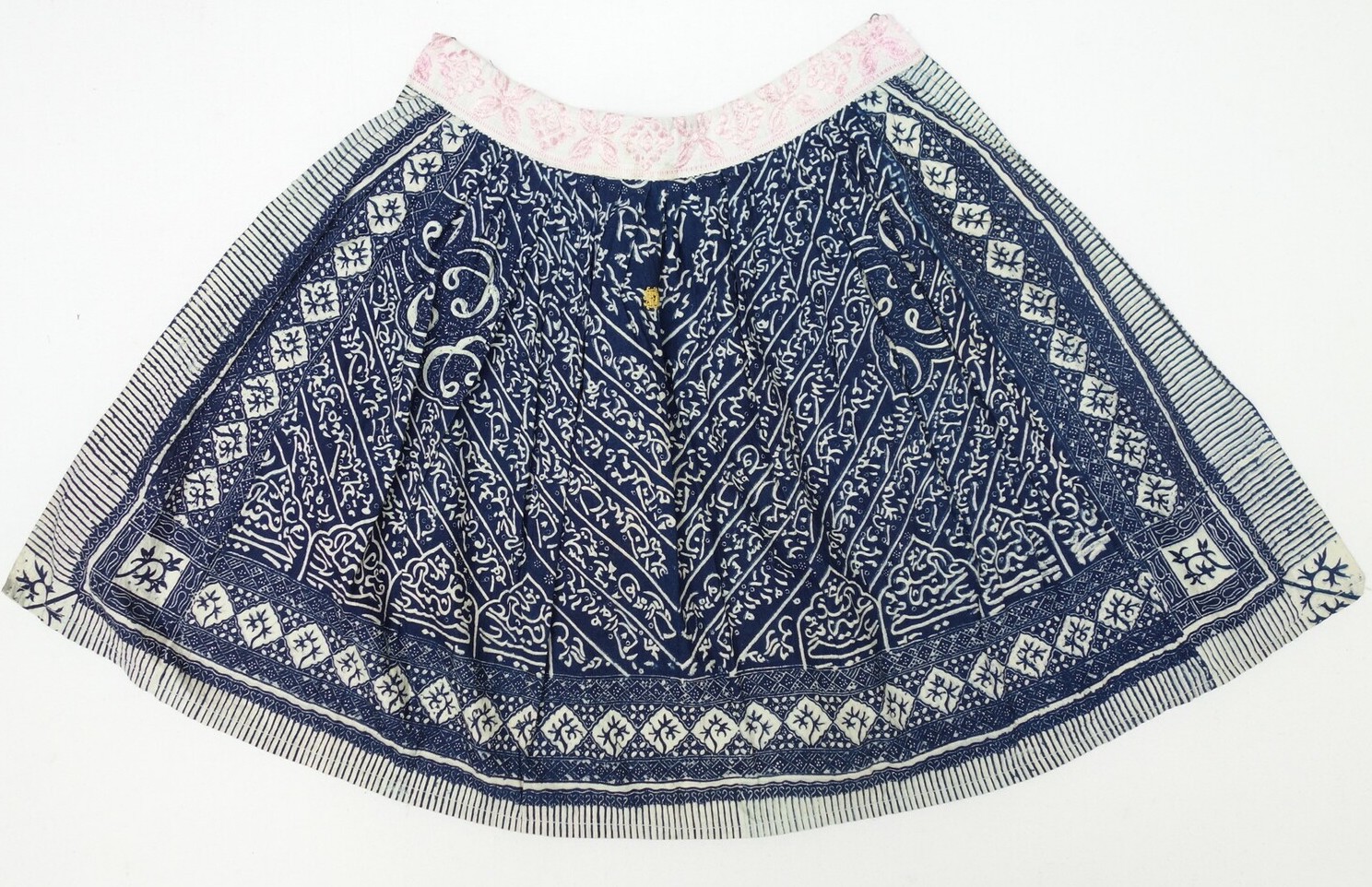 Fig. 3. Blue/white apron from the island of Marken, the Netherlands, with an Arabic script-like design, an embroidered monogram DK in yellow, and with a white band that is embroidered in pink (TRC 2009.0048).