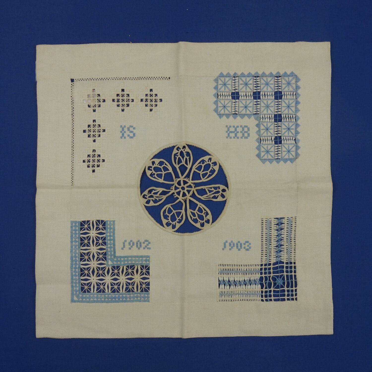 Sampler in ecru and blue with several techniques. Initials: "IS, HB, 1902 1903" in satin stitch. Worked by Henriëtte Slavekoorde-Braunstahl, 1903 (TRC 2017.0107).