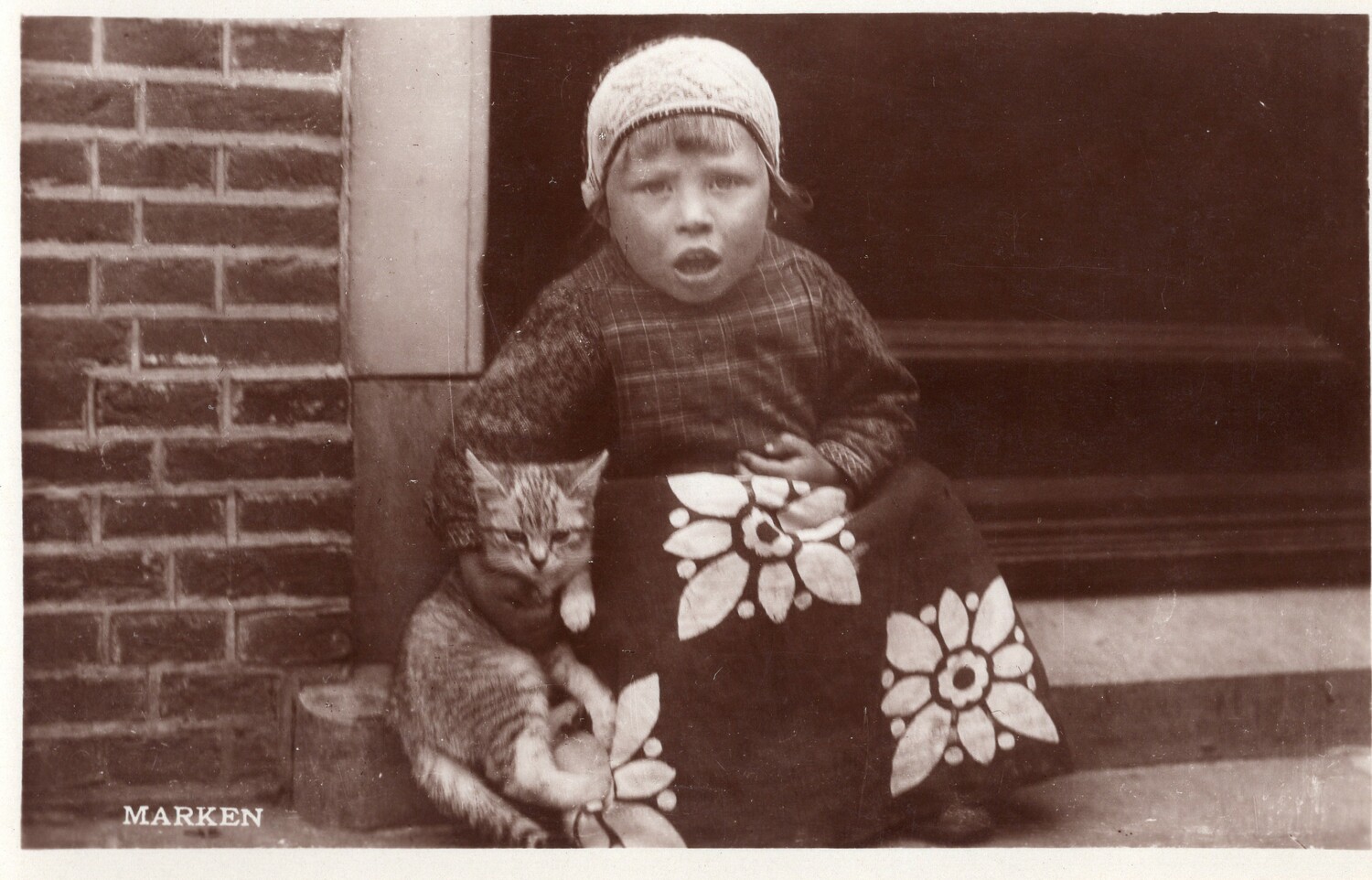 Postcard, c. 1950, from the Dutch island of Marken, with a boy holding a cat (TRC 2018.0464).