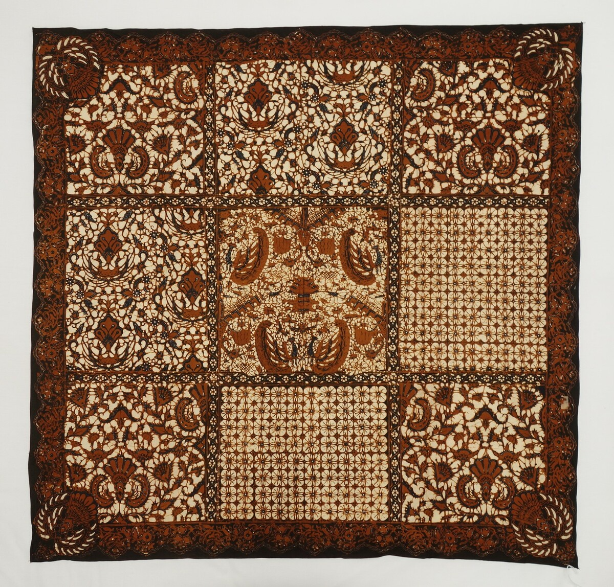 Batik cotton cloth from Java, Indonesia, mid-20th century, with a black, brown and off-white design including stylised flowers and quatrefoils (TRC 2018.2883).