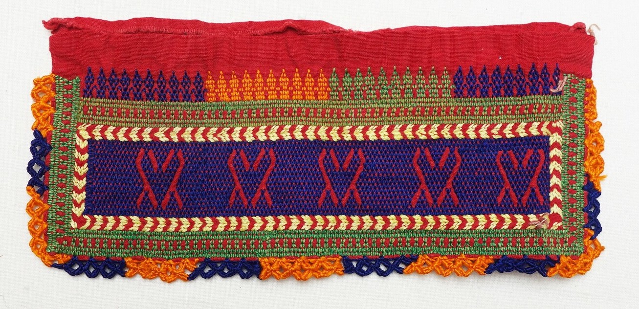 Detail of an embroidered panel from Jordan, with a negative design set within a purple ground, 20th century (TRC 2019.1715).