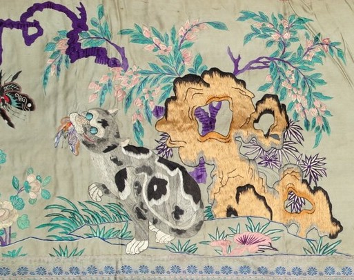 Detail of an early 20th century embroidered Chinese panel with a cat catching and eating butterflies (TRC 2019.2338).