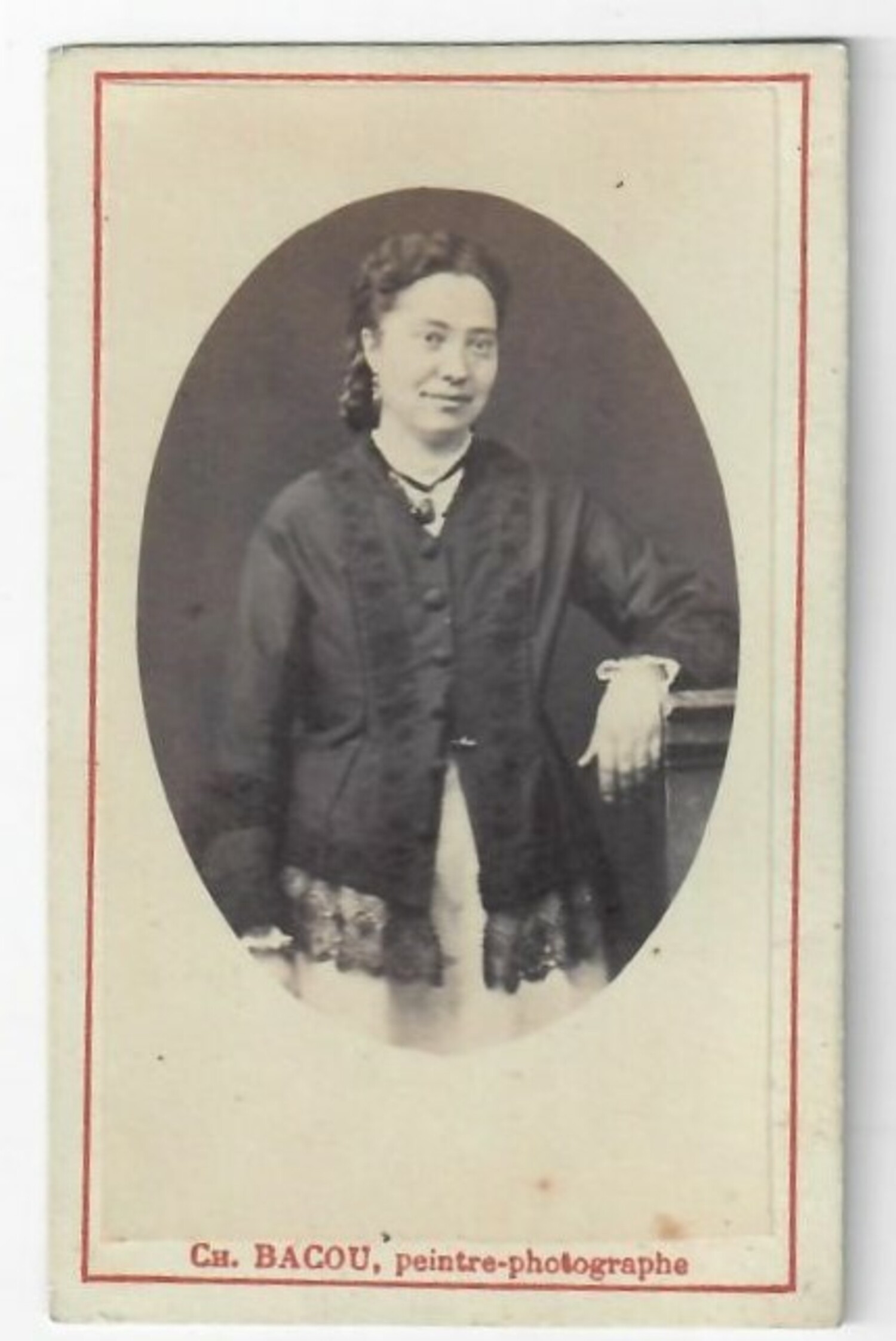 Early 20th century carte de visite from France, with a photograph of a standing women wearing a dark coloured blouse with a lace edging (TRC 2020.5161).