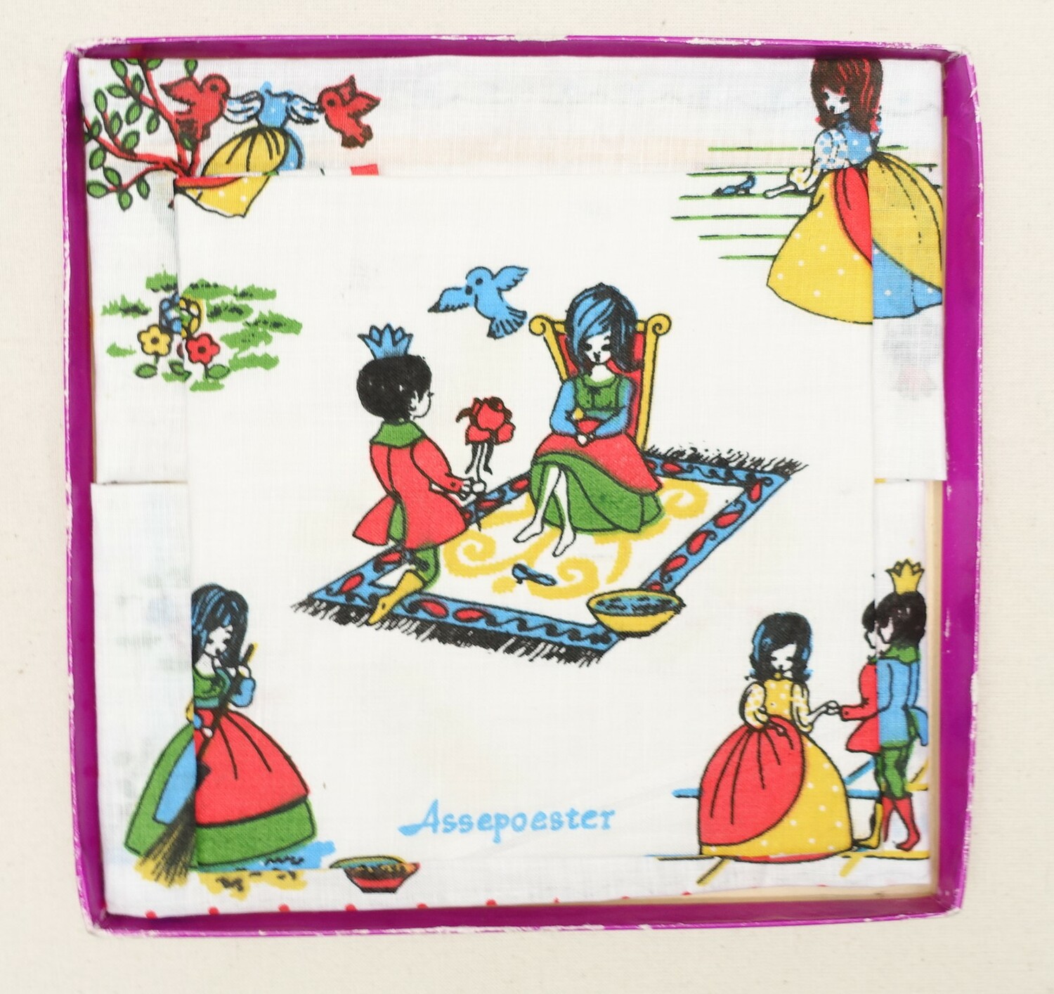 Box of (badly printed) handkerchiefs, folded in a decorative manner. The Netherlands, 20th century. One of the handkerchiefs has the text 'Assepoester' (Cinderella) (TRC 2021.3393).