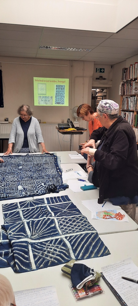 Participants of the TRC study day on sub-Saharan embroidery look at stitch-resist textiles from Nigeria. Photograph by Augusta de Gunzbourg.