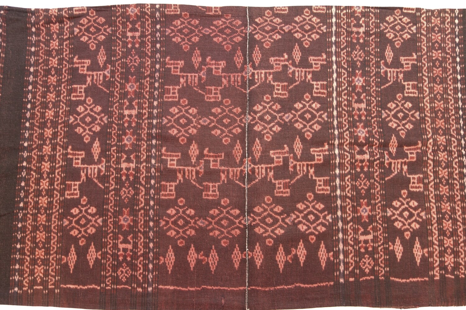 Detail of Ikat cloth that is decorated with stripes of various widths with geometric and abstract shapes in off-white, dark red and black on a black ground. Flores, Indonesia, 1950-1980 (TRC 2022.0857).