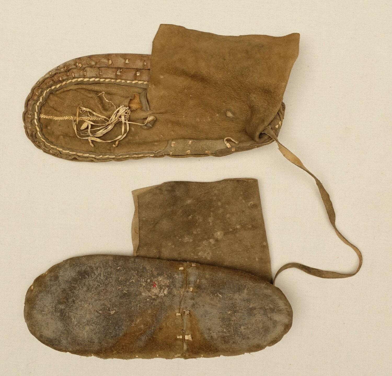 Pair of handmade shoes with both leather and suede elements. The vamp seams are decorated with a line of embroidery using narrow strips of leather. Nuristan (Afghanistan, 1960s (TRC 2022.1933a b).