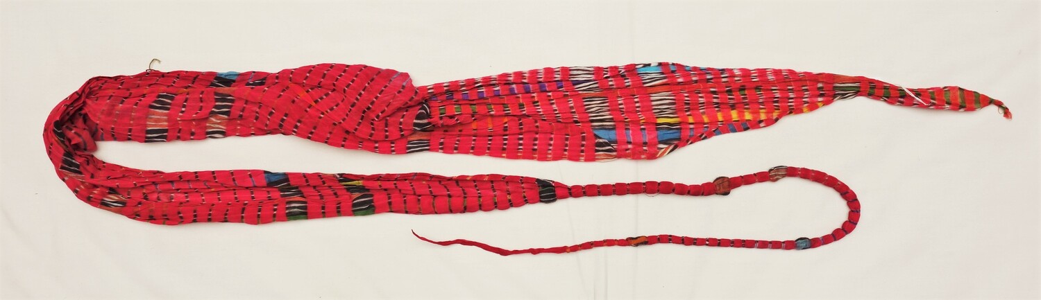 Long roll of cloth that has been tied at regular intervals prior to dyeing in order to create diagonal stripes in varous colours.on a magenta ground. Jaipur, Rajasthan, India, 1980 (TRC 2022.2120).