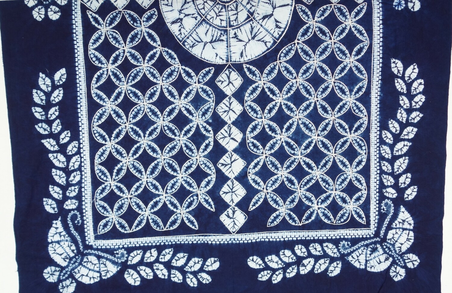 Factory woven (tabby weave) cloth, hand resist dyed (tie-dyed), machine embroidered. Mali, late 20th century (TRC 2023.1196).