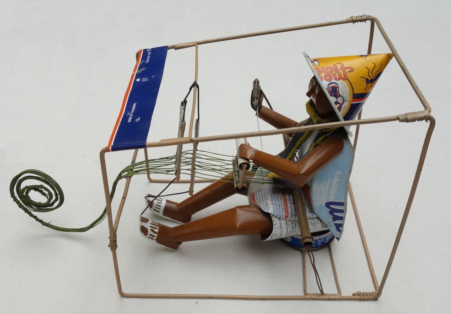 Model of a man working at a frame loom made from old pieces of tin cans and metal strips. Mali, late 20th century (TRC 2023.1212).