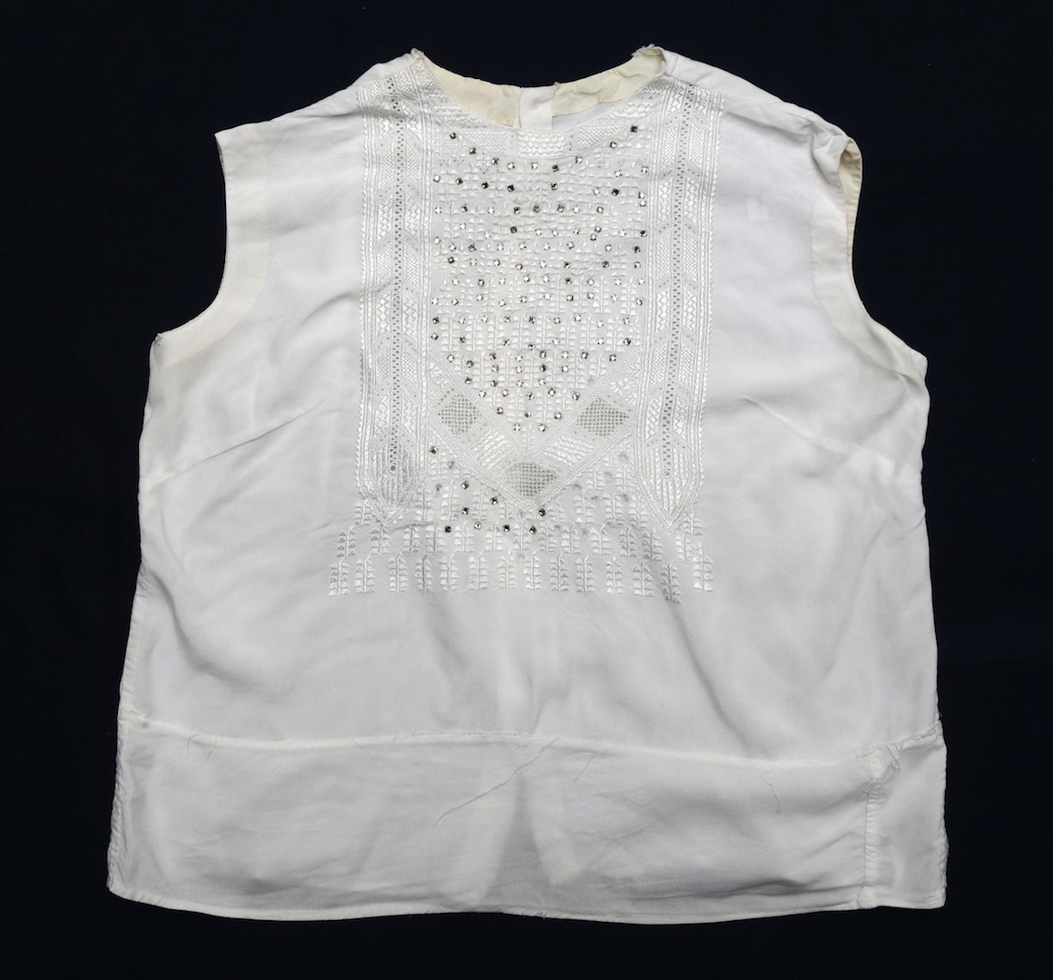 Blouse made in Kabul for a Western woman, with short sleeves and buttons on the back, but decorated with Kandahar-style whitework (khamak). Afghanistan, 1960s-1970s (TRC 2024.0223).