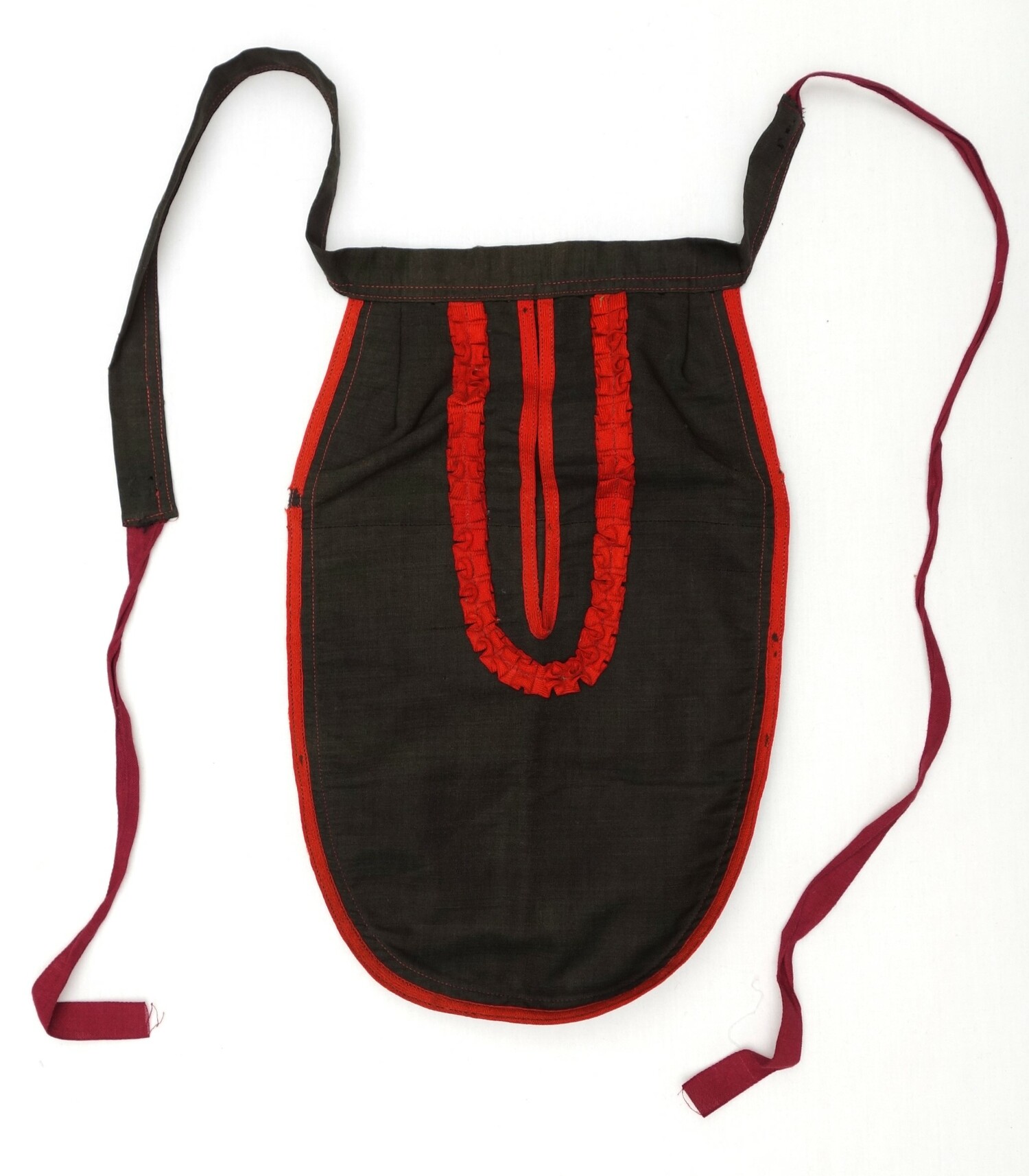 A black worsted cloth under pocket decorated with frills made from a red woollen band, The Netherlands, late 19th century (TRC 2024.1113).