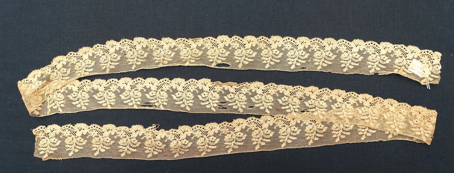 Voorbeeld van kloskant met een patroon van gestileerde bloemtakken op een rand met bloemhoofdjes van verschillende grootte en golvende lijnen. Nederland, 19e eeuw (TRC 2025.0566).