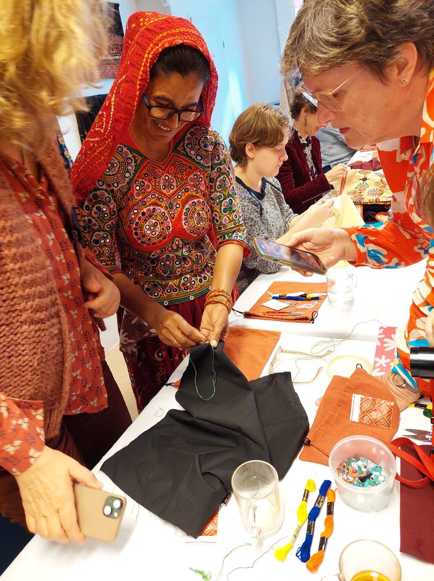 Shisha embroiderer Geetaben Meriya, from Gujarat’s Kutch region, helps participants at the TRC’s recent masterclass in shisha work.  Photo by Shelley Anderson