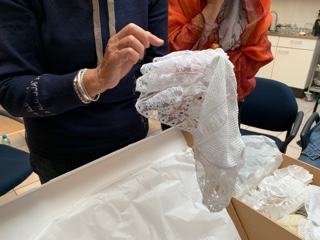 Inspecting a lace cap from the TRC collection.