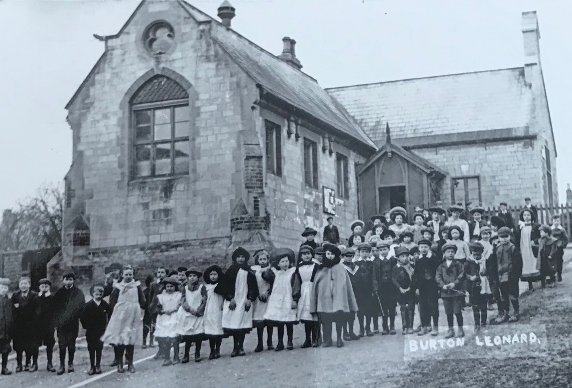 Children in front of the Burton Leonard school, c. 1900. Postcard.