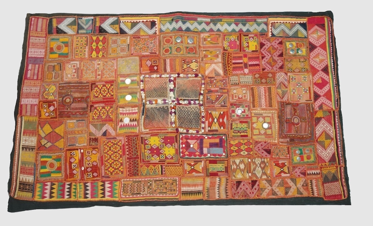 Patchwork of various squares and rectangles of (mainly) Banjara embroidery with a wide variety of repeating, geometric patterns in various colours. India, 20th century (TRC 2024.2190).