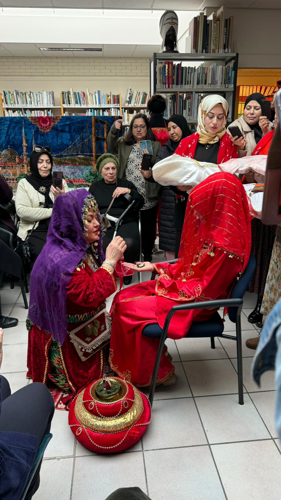 De aanstaande bruid krijgt een munt geplaatst op de met henna versierde hand.