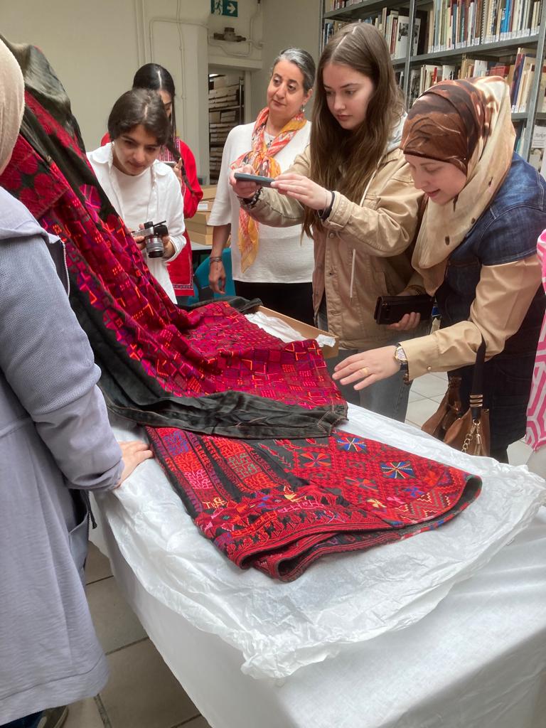 A group of women with a Middle Eastern background discussing Syrian garments. Photograph by Maria Linkogle.