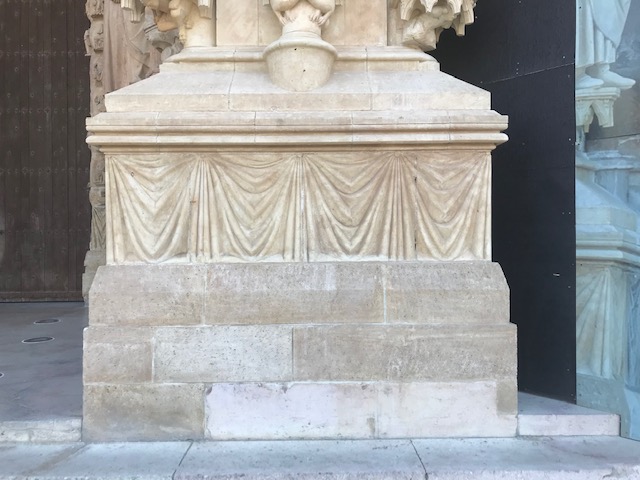 Sculptured, draped curtains at the entrance to Reims cathedral (photograph Willem Vogelsang).