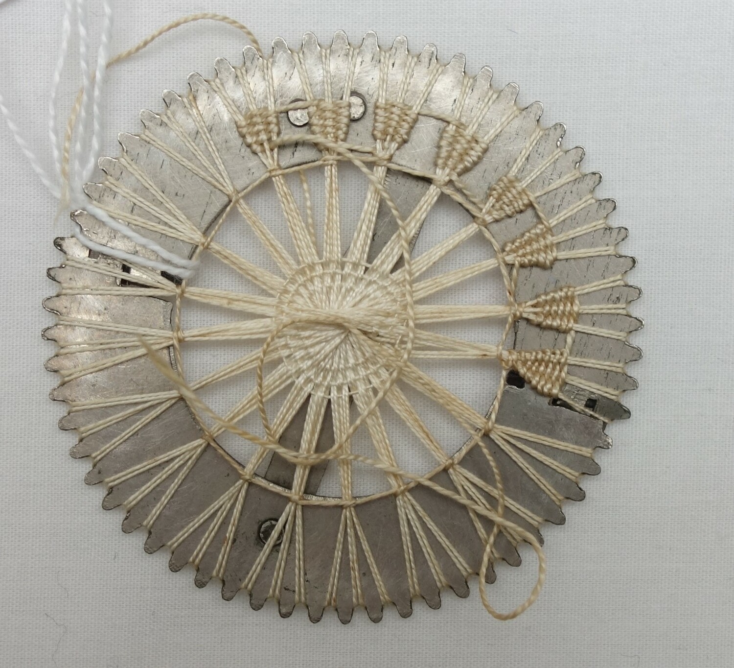 Tenerife lace metal wheel, with the beginning of a needle woven pattern, early 20th century (TRC 2023.2316c).