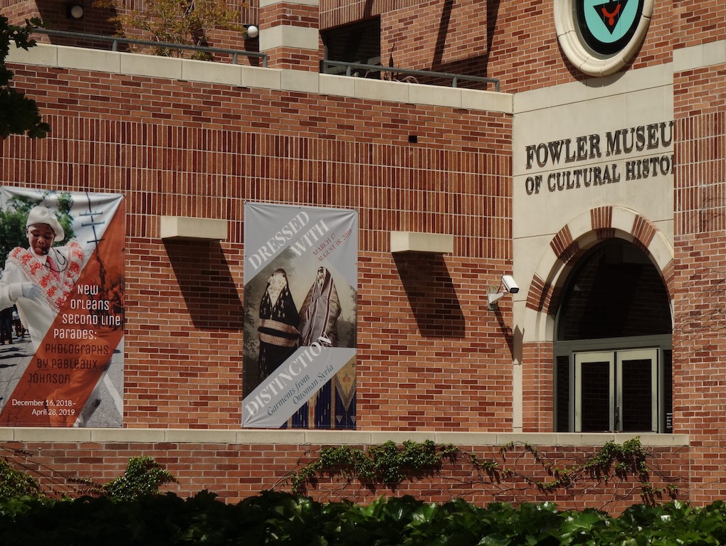 Entrance to the Fowler Museum and exhibition, with in the centre a poster of the 'Dressed with Distinction' exhibition.