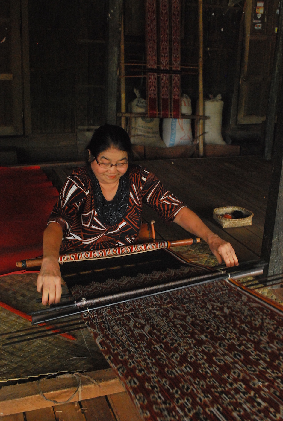 Craftswoman from Sintang Regency, Kalimantan, Indonesia, working on her loom making ikat cloth. 