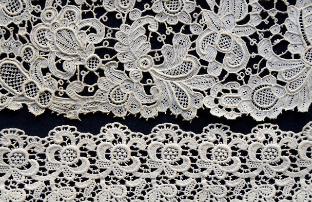 Photorgaph showing two pieces of lace. The one on top (TRC 2007.0559) is handmade, the one below (TRC 2007.0595) is machine made.